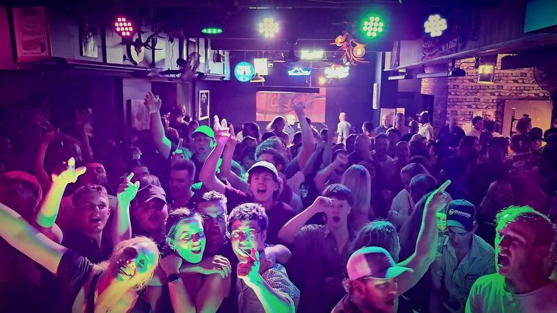Crowd with hands up under purple lights